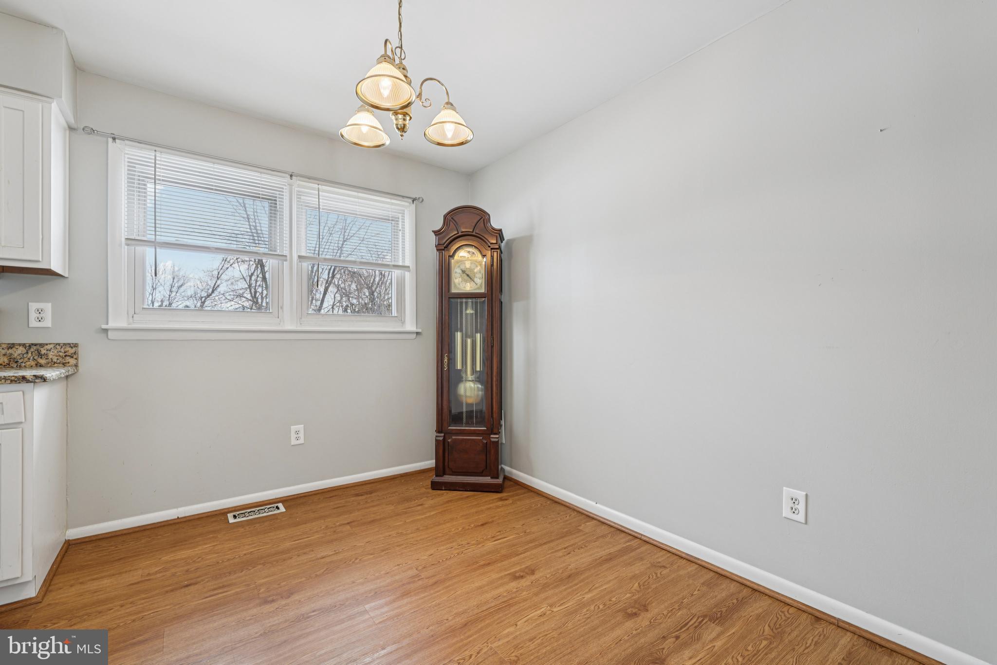 917 Century Street Hampstead, MD 21074 - Photo 10 of 45 an empty room with wooden floor cabinet and windows
