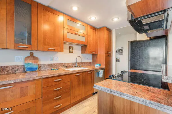 a kitchen with stainless steel appliances kitchen island granite countertop a sink stove and cabinets