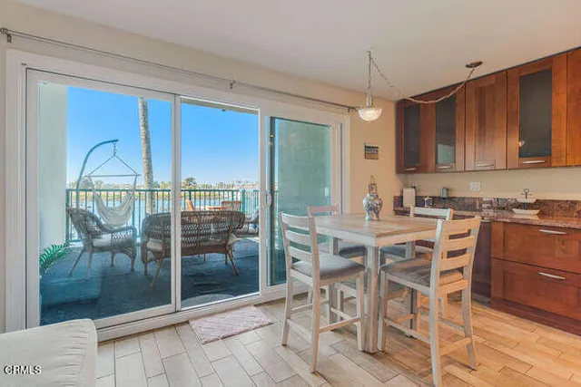 a view of a dining room with furniture wooden floor and a kitchen view