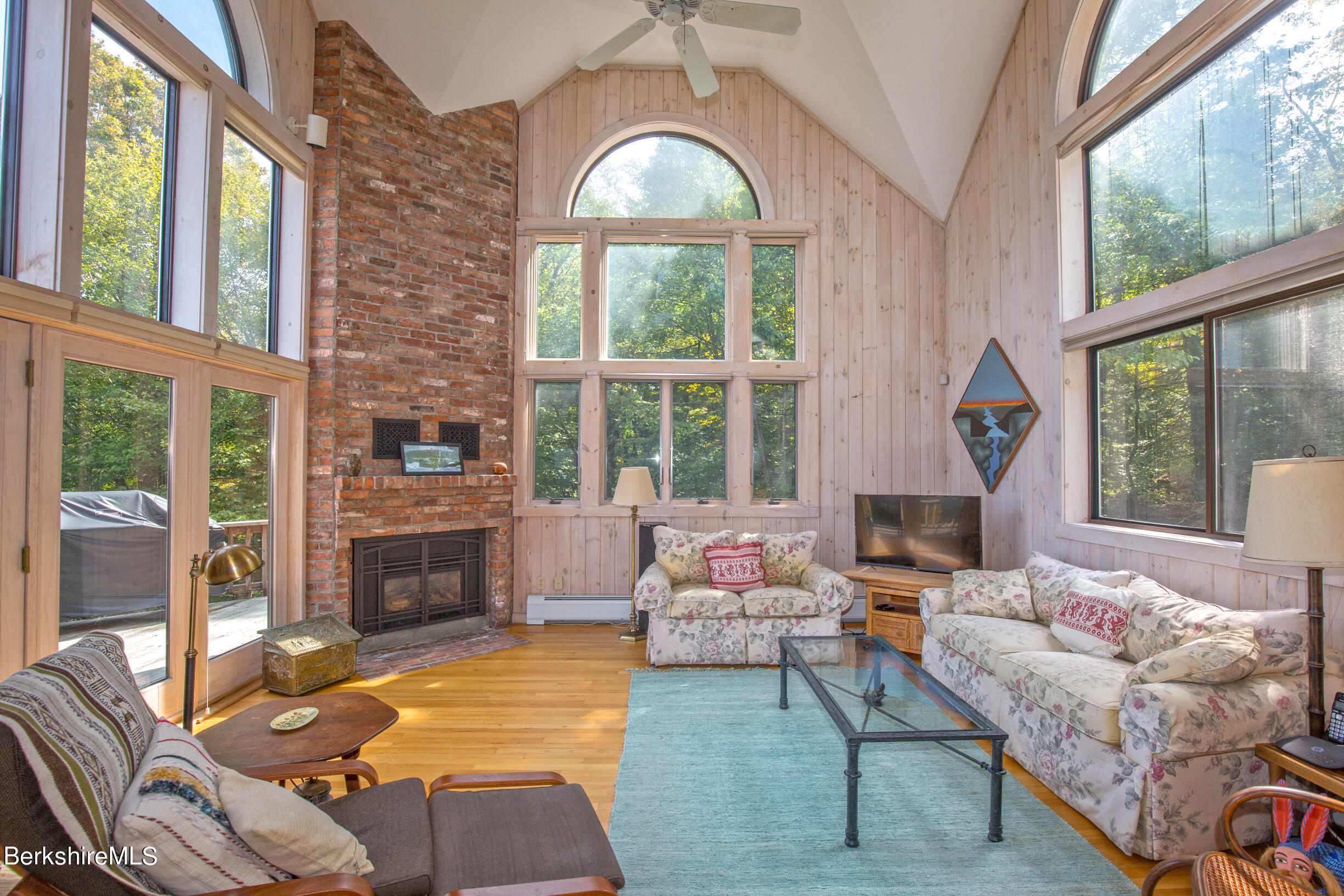 795 Moberg Road Becket, MA 01223 - Photo 16 of 41 a living room with furniture a fireplace and large windows