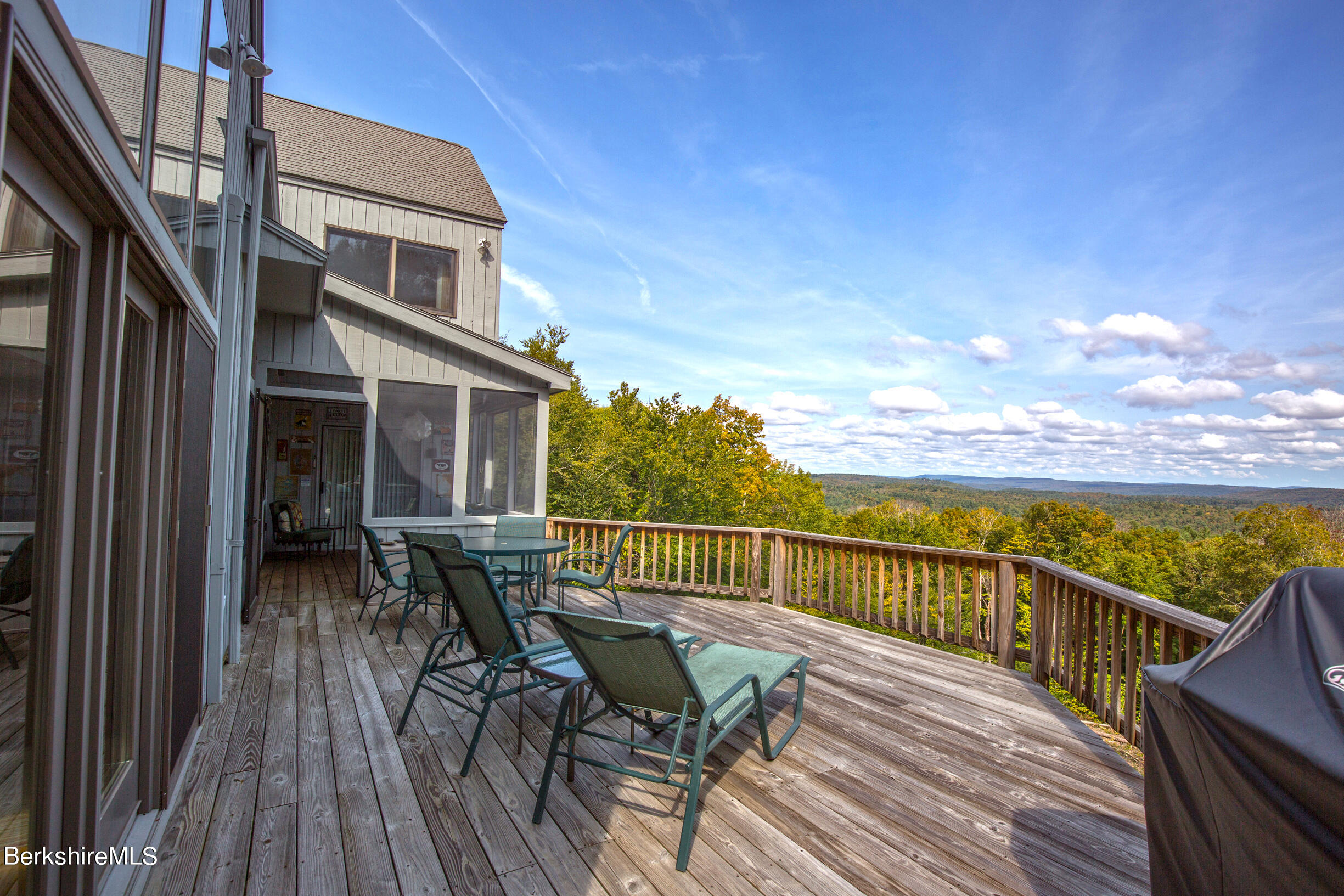 795 Moberg Road Becket, MA 01223 - Photo 7 of 41 a view of a balcony with two chairs and wooden floor