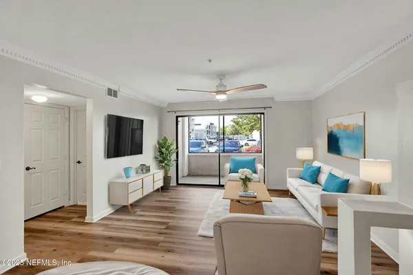 a living room with furniture a flat screen tv and a large window