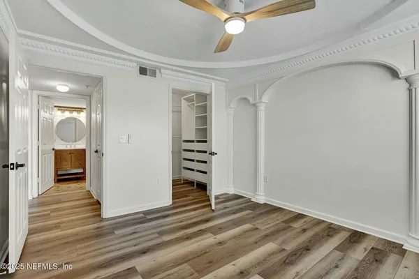 a view of a hallway with wooden floor and closet