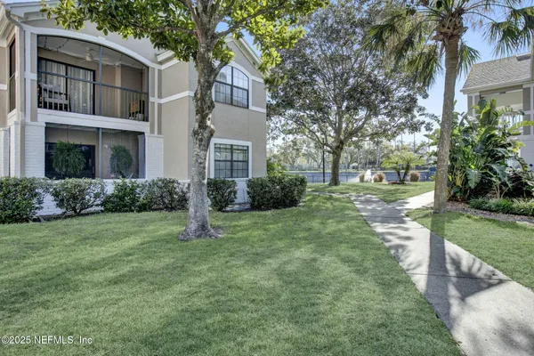 a view of a house with a yard and tree s