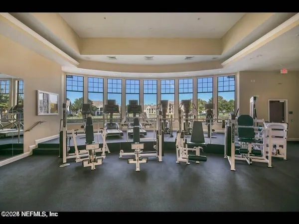 a living room with gym equipment and floor to ceiling window