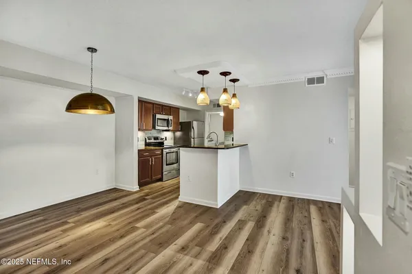 a view of a kitchen with wooden floor and window