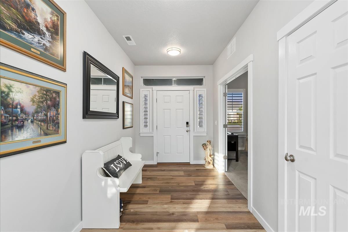 15451 Lutsen Avenue Caldwell, ID 83607 - Photo 5 of 39 Entryway featuring wood-finish flooring, white paneled doors, and a front entry door with transom and sidelight windows