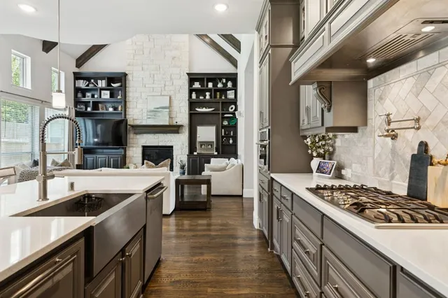 a kitchen with stainless steel appliances granite countertop a sink stove and cabinets