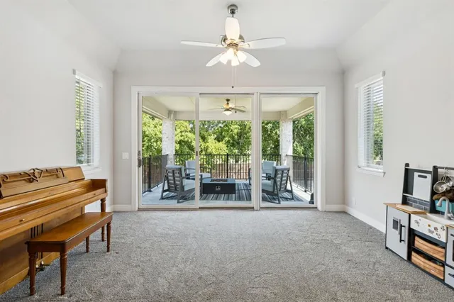 a living room with furniture a flat screen tv and a large window
