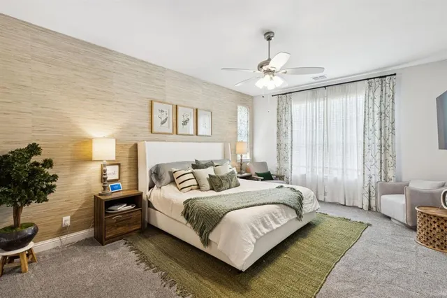 a bedroom with a bed a couch and potted plant