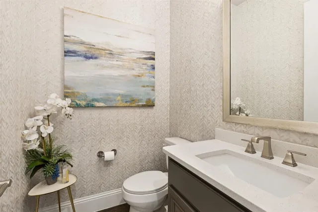 a bathroom with a granite countertop sink and a toilet