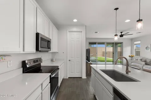 a kitchen with stainless steel appliances granite countertop a sink a stove and a wooden floors