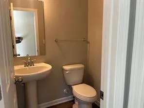 a bathroom with a toilet a sink and mirror
