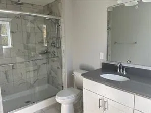 a bathroom with a sink a toilet and shower