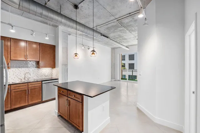 a kitchen with stainless steel appliances granite countertop a sink and dishwasher a refrigerator with wooden cabinets