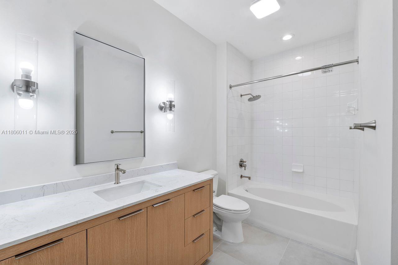 2001 Biscayne Boulevard, Unit 2308 Miami, FL 33137 - Photo 13 of 29 a bathroom with a granite countertop sink a toilet and shower