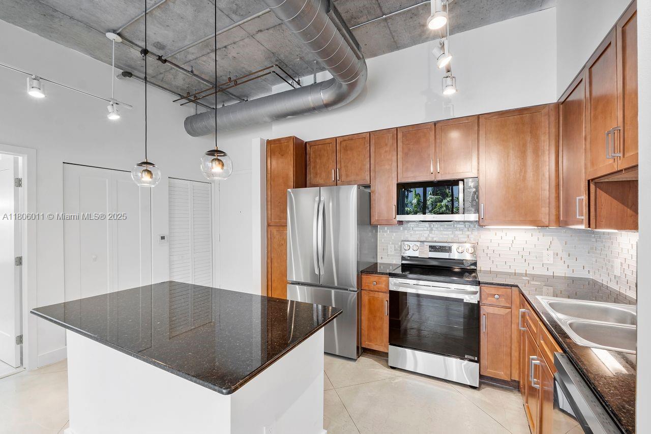 2001 Biscayne Boulevard, Unit 2308 Miami, FL 33137 - Photo 9 of 29 a kitchen with kitchen island a counter top space stainless steel appliances and cabinets