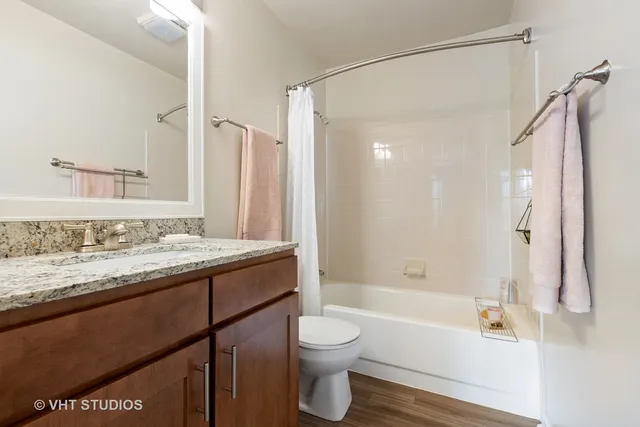 a bathroom with a granite countertop sink toilet and shower