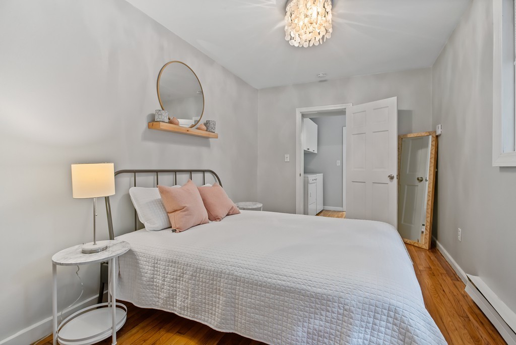 8 Dwight Street, Unit 1 Boston, MA 02118 - Photo 11 of 20 a bedroom with a bed and a chandelier