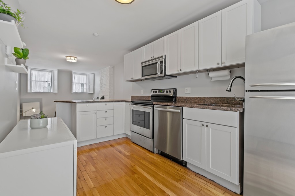 8 Dwight Street, Unit 1 Boston, MA 02118 - Photo 9 of 20 a kitchen with stainless steel appliances granite countertop a sink and cabinets with wooden floors