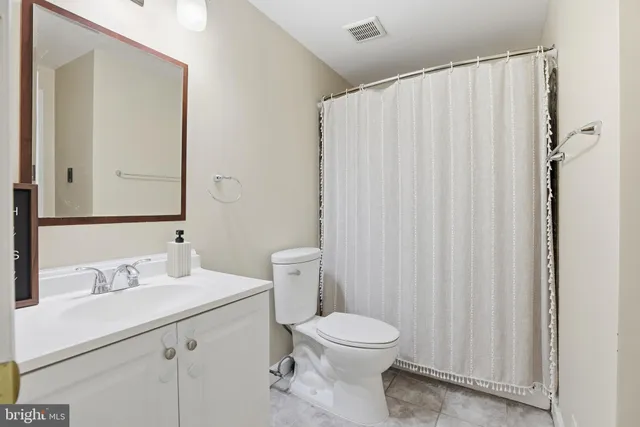 a bathroom with a toilet a sink and a mirror