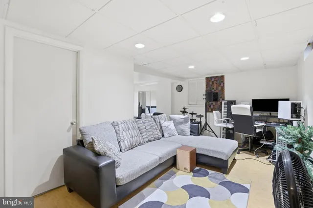 a living room with furniture a flat screen tv and a window