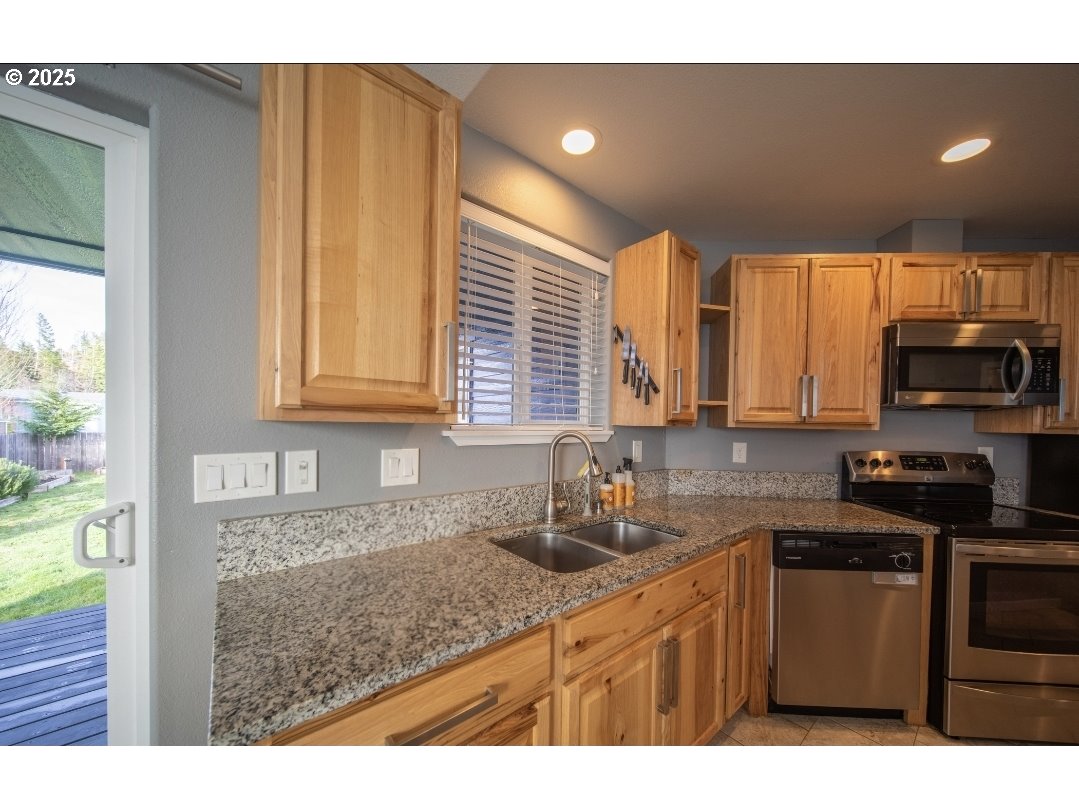 1010 Raechel Road Lakeside, OR 97449 - Photo 18 of 44 a kitchen with stainless steel appliances granite countertop a sink stove and cabinets