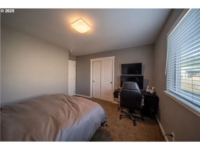 a bedroom with a bed and a flat screen tv