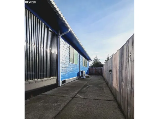 a view of backyard with wooden fence