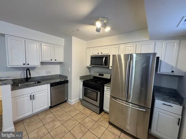 a kitchen with stainless steel appliances granite countertop a refrigerator sink and stove