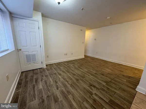 a view of an empty room with wooden floor