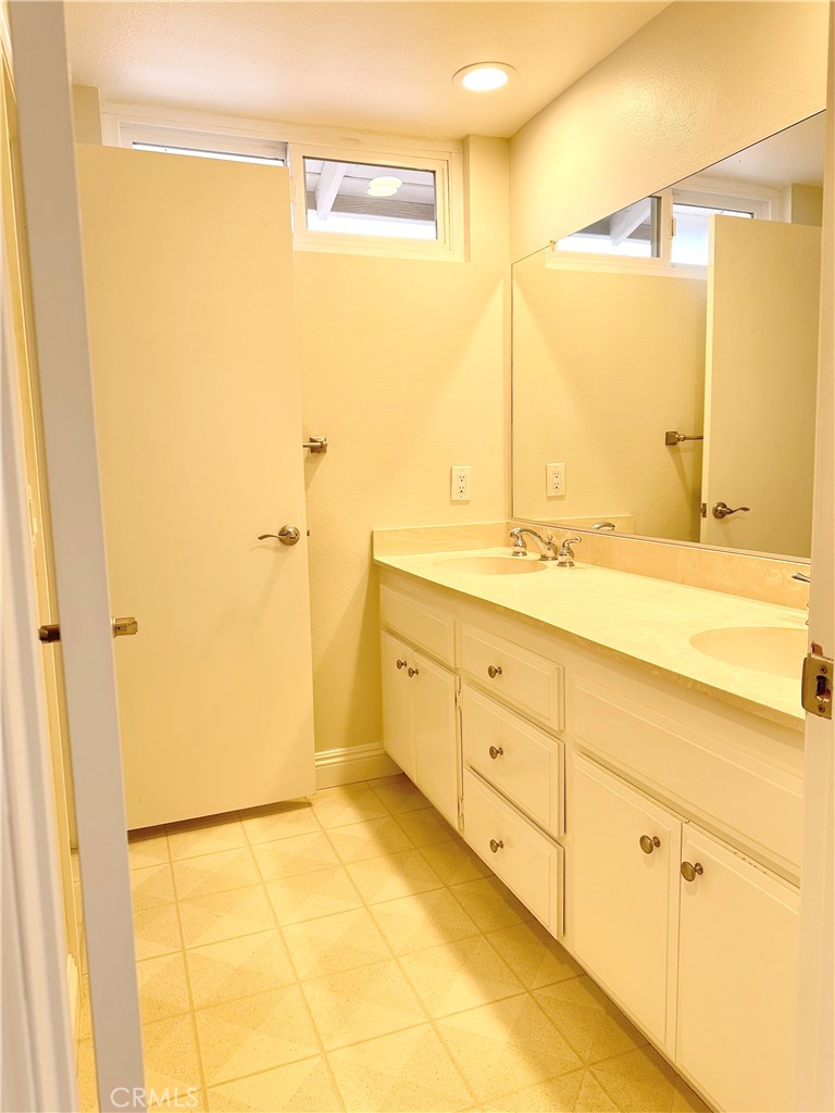 23 Whistling Swan Irvine, CA 92604 - Photo 17 of 26 a bathroom with a granite countertop sink a mirror and a shower