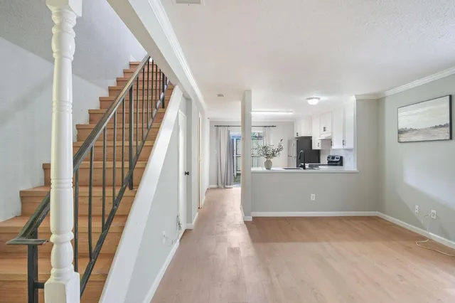 a view of a hallway with wooden floor and staircase