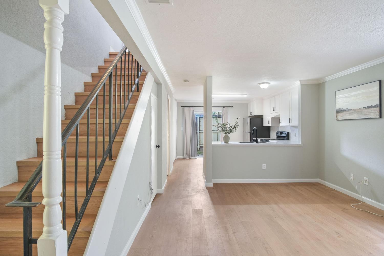 a view of a hallway with wooden floor and staircase