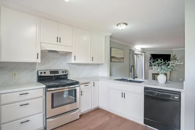a kitchen with granite countertop white cabinets and white appliances