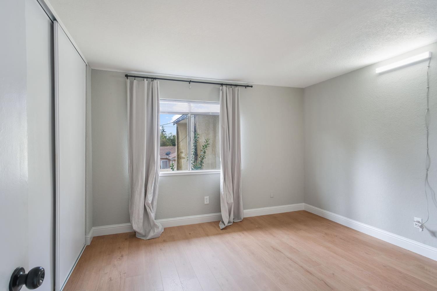 348 Wayside Drive Turlock, CA 95380 - Photo 15 of 22 an empty room with wooden floor and windows