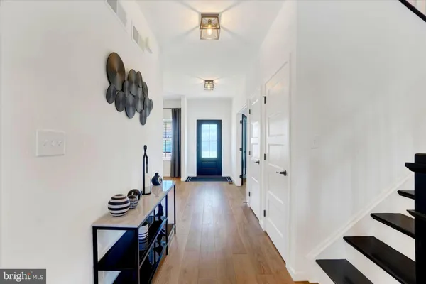 a view of a hallway with furniture and wooden floor