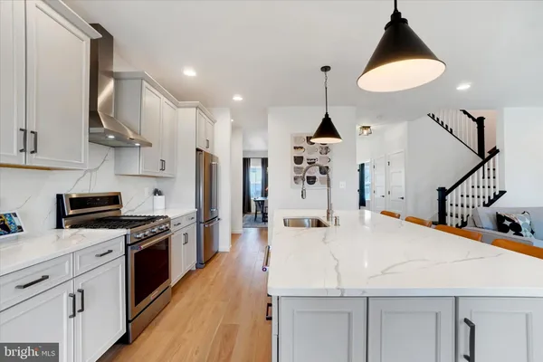 a kitchen with stainless steel appliances kitchen island granite countertop a stove a sink and a refrigerator