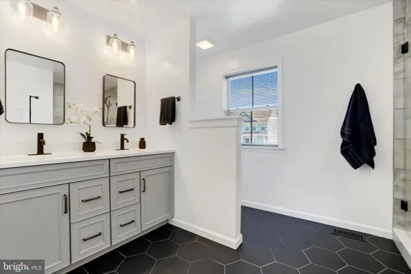 a bathroom with a double vanity sink and mirror