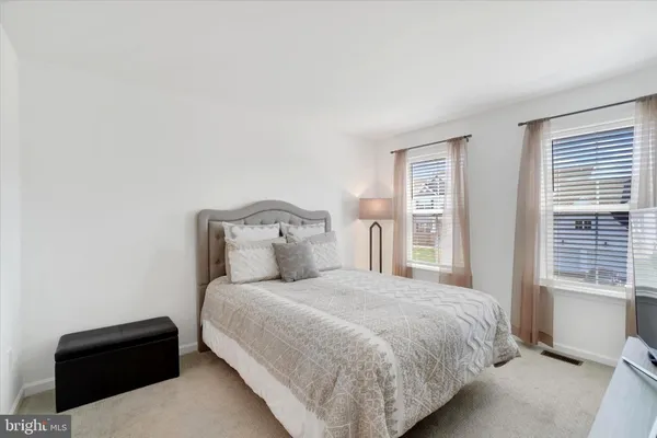 a bedroom with a bed lamp and a window