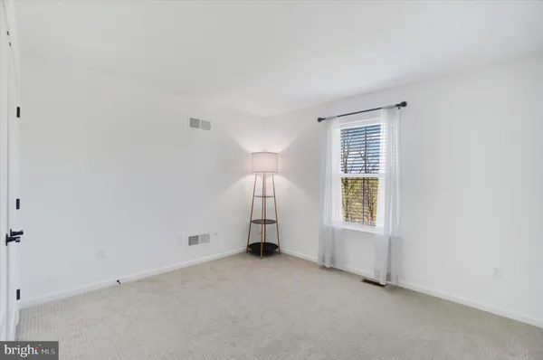 an empty room with a window and a fireplace