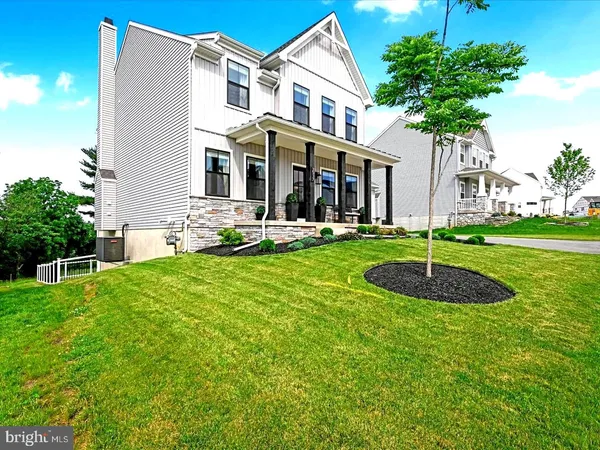 a front view of a house with garden and trees