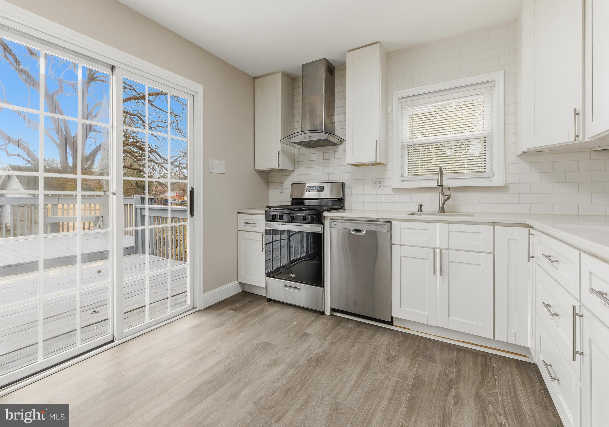 127 Madison Avenue Laurel Springs, NJ 08021 - Photo 6 of 22 a kitchen with cabinets stainless steel appliances a sink and wooden floor