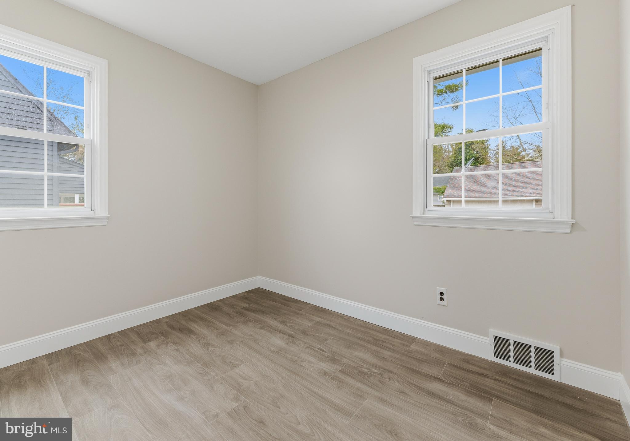 127 Madison Avenue Laurel Springs, NJ 08021 - Photo 8 of 22 an empty room with wooden floor and windows