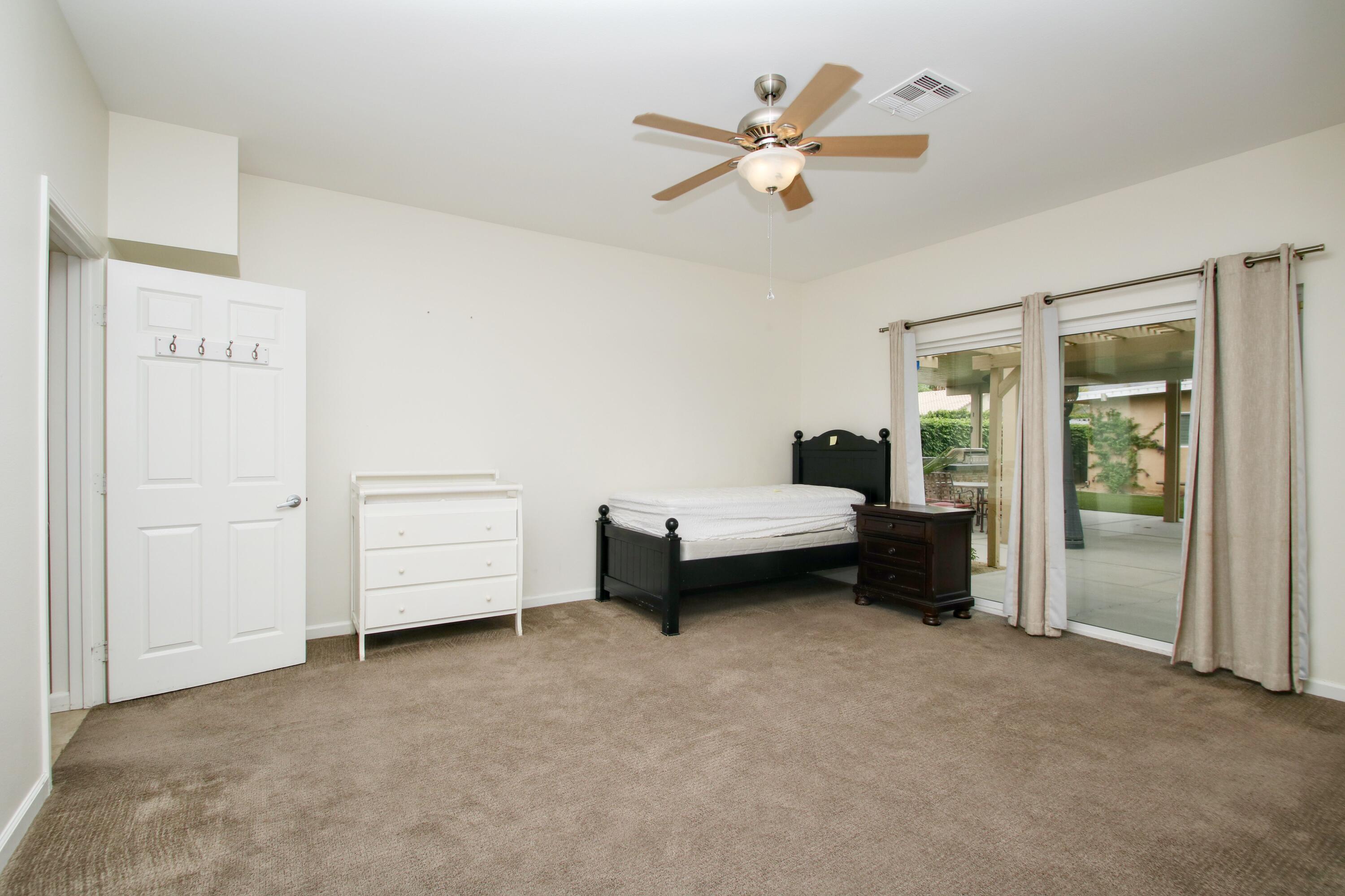 44755 Deep Canyon Road Palm Desert, CA 92260 - Photo 8 of 16 a bedroom with furniture and a ceiling fan