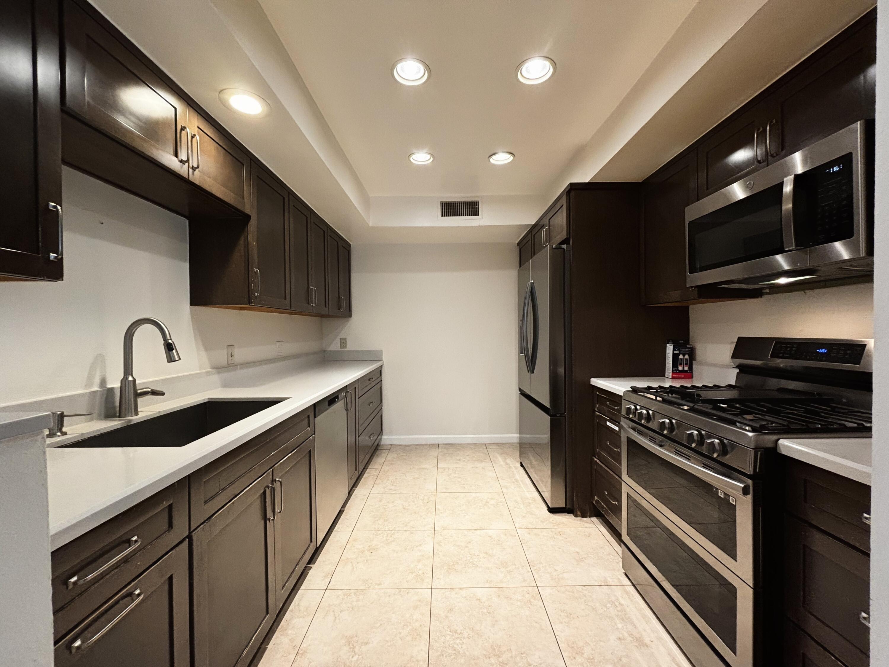 44755 Deep Canyon Road Palm Desert, CA 92260 - Photo 10 of 16 a kitchen with stainless steel appliances a sink a stove top oven a refrigerator and dishwasher