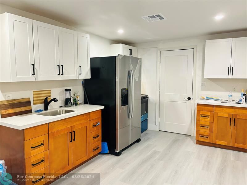 a kitchen with stainless steel appliances granite countertop a refrigerator a stove and white cabinets