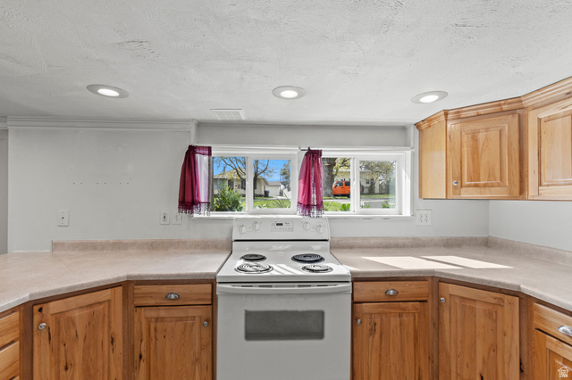 180 South 300 East Logan, UT 84321 - Photo 22 of 35 Kitchen with electric stove, light countertops, recessed lighting, and a textured ceiling