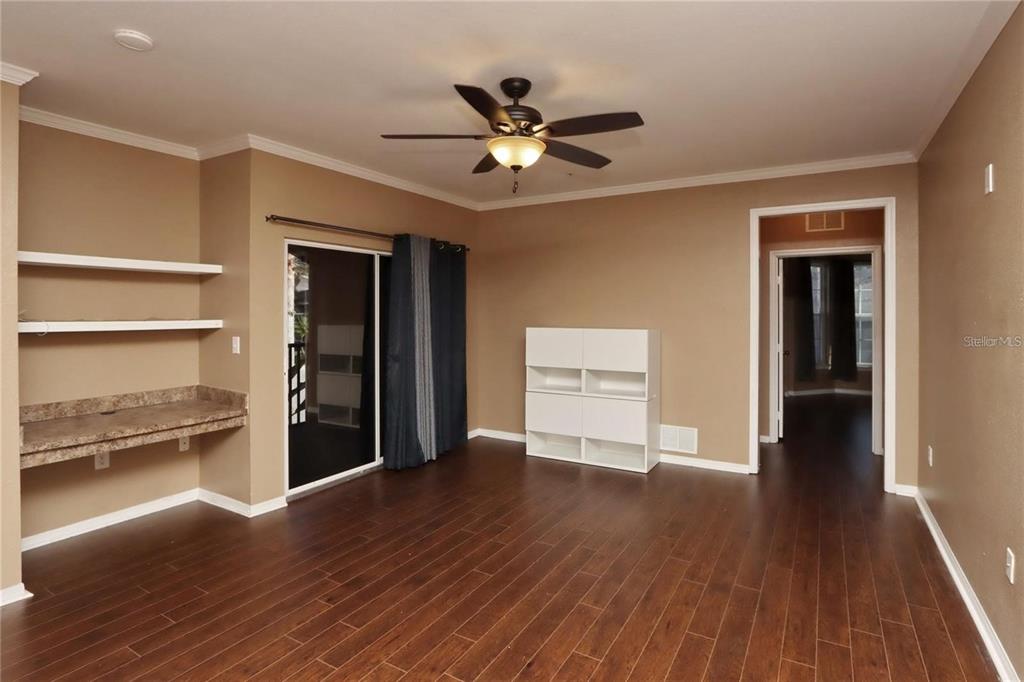 9918 Courtney Palms Boulevard, Unit 201 Tampa, FL 33619 - Photo 12 of 24 a view of an empty room with a window and wooden floor