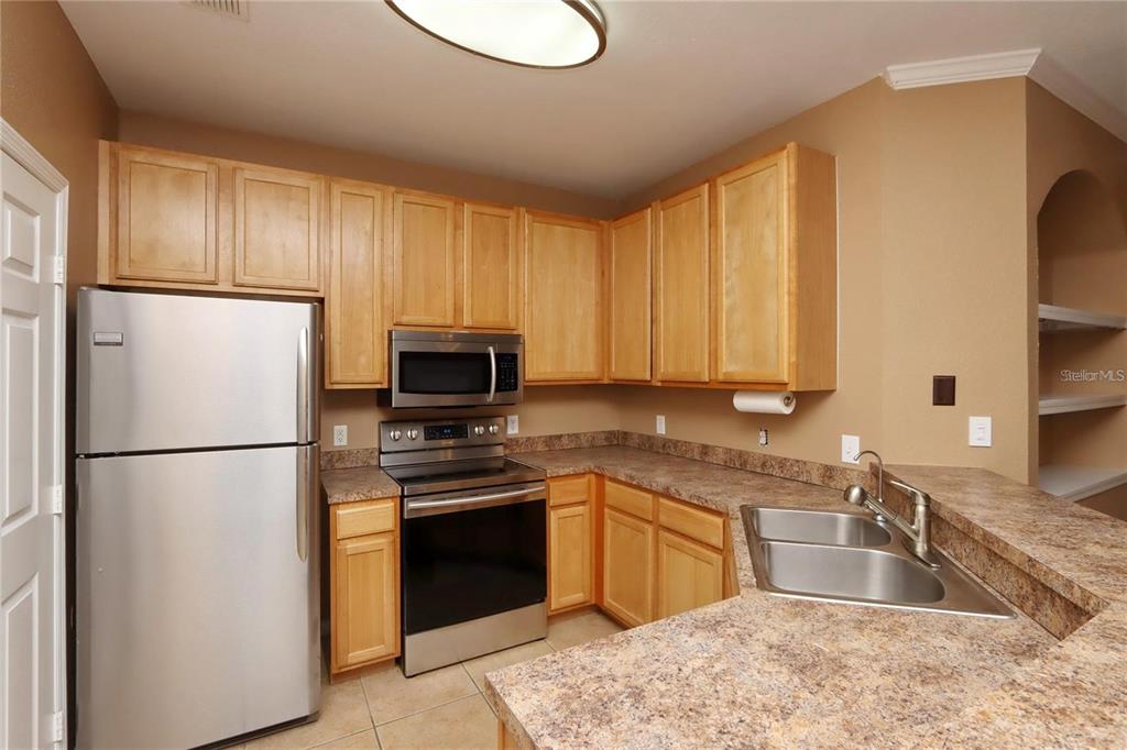 9918 Courtney Palms Boulevard, Unit 201 Tampa, FL 33619 - Photo 13 of 24 a kitchen with a refrigerator sink and microwave